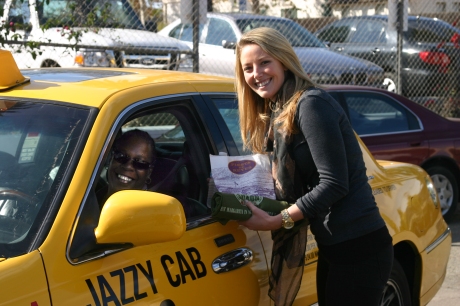 Fiesta de Reyes Group Sales Manager Amber Baker hands a Fiesta de Reyes lunch to a Jazzy Cab taxi driver.